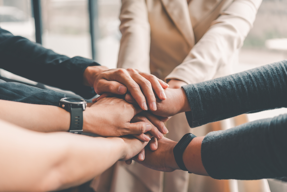 Business-people-putting-hands-together-during-team-meeting