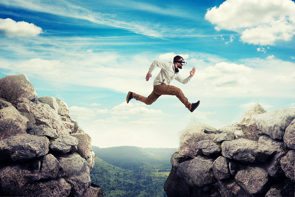 an-wearing-VR-headset-jumping-from-one-pile-of-rocks-to-another