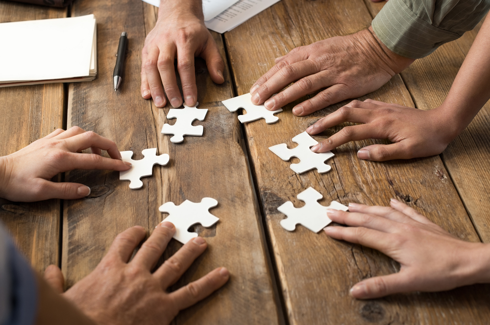 Team-putting-together-puzzle-pieces
