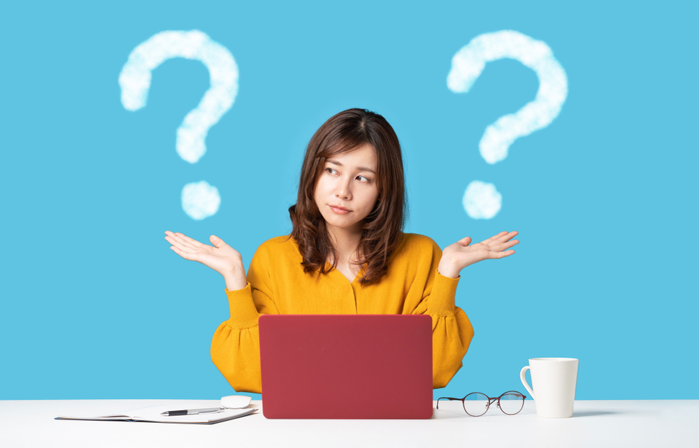 Woman-with-hands-in-the-air-comparing-two-options-while-working-on-laptop